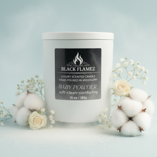 Black Flamez Baby Powder candle in a soft powder-blue setting with cotton, white flowers, and airy light